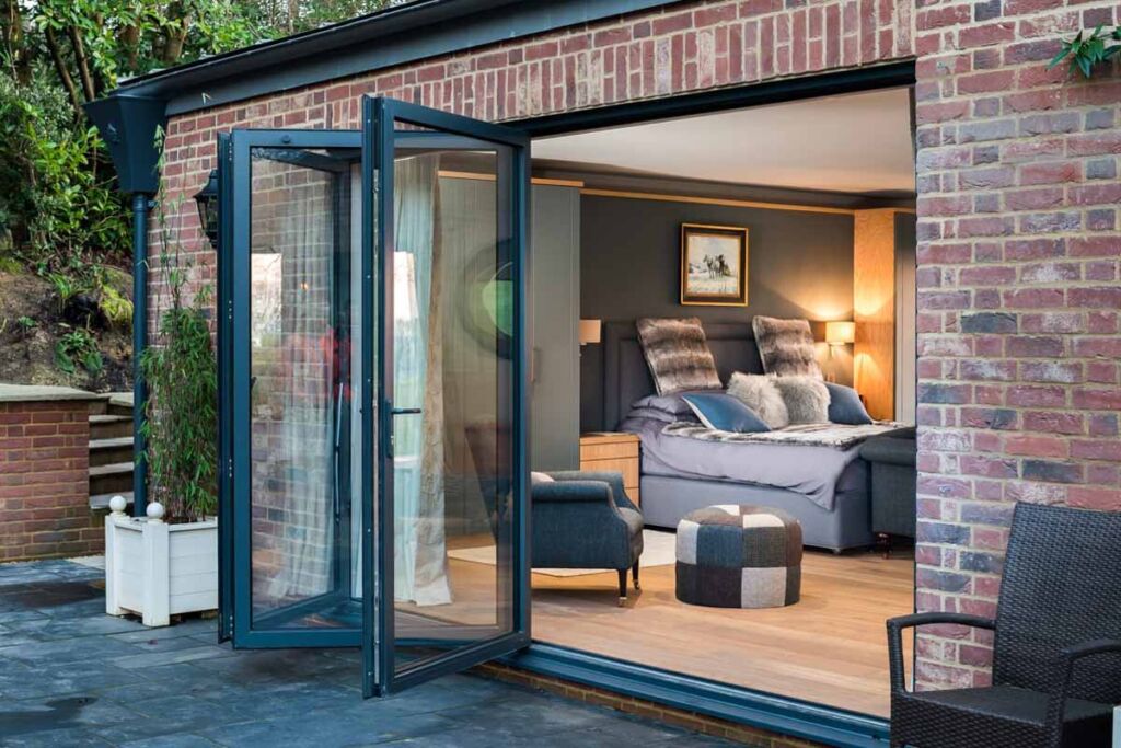 A picture of a house extension with aluminium bifolds that are open creating the feeling of space by having an open plan house and garden